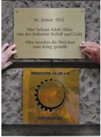 Eine Mahntafel wird provisorisch von den VVN-BdA-Aktivisten Falk Mikosch (Landessprecher) und Jürgen Schuh (Landesgeschäftsführer) am Industrieclub angebracht.